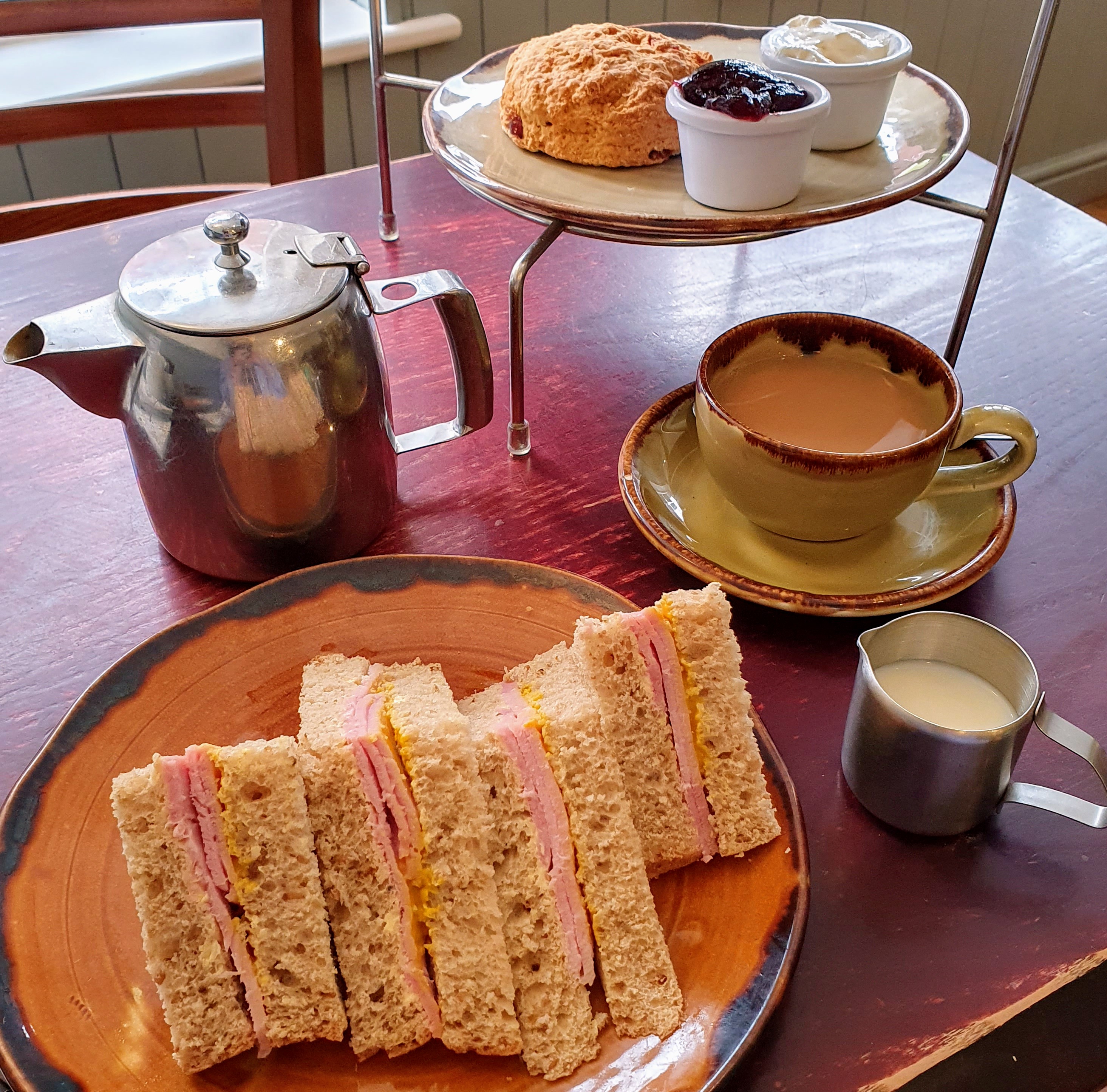 Ham sandwiches with Cup of tea, teapot and cherry scone. Coffee Beans Café, Leek, Staffordshire