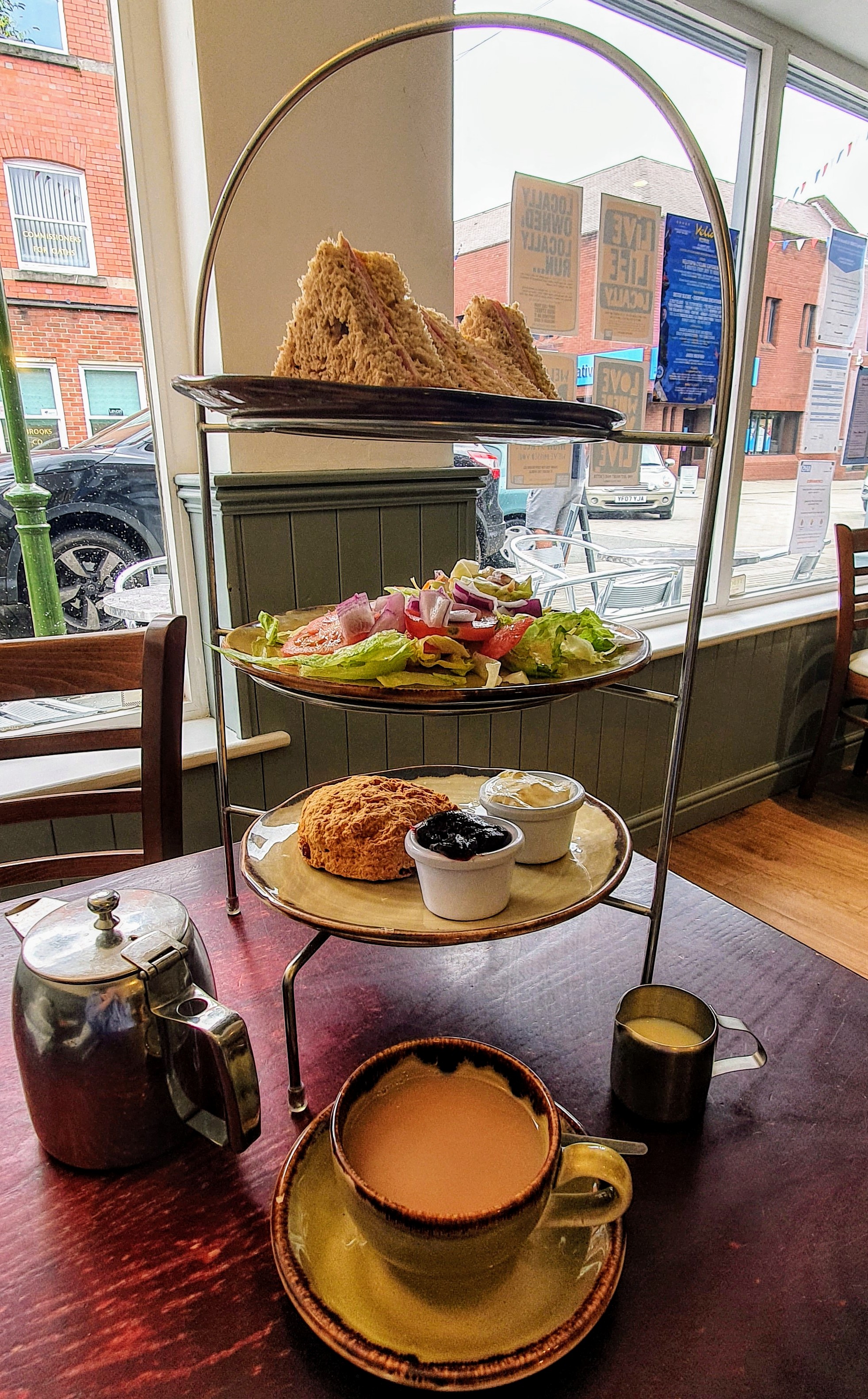 Afternoon tea at Coffee Beans Café with sandwiches, salad and scone. Also a cup of tea and a teapot. Leek, Staffordshire
